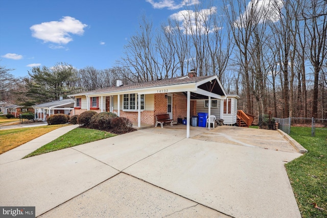 ranch-style home featuring a front lawn and a carport