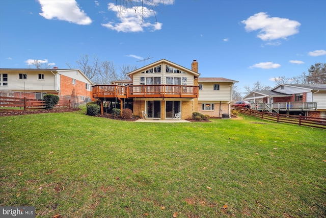 rear view of house with a lawn and a wooden deck