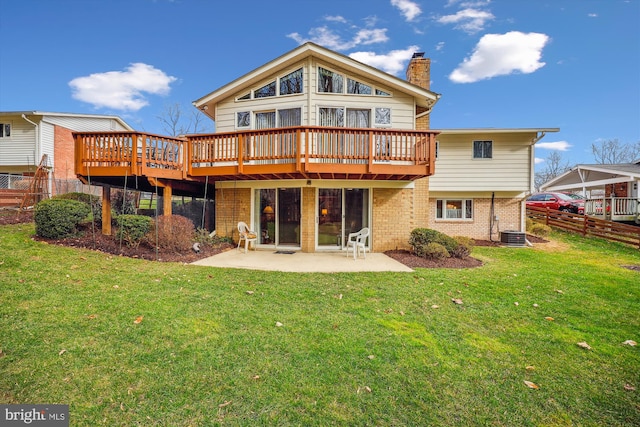 rear view of house featuring a patio area, a wooden deck, a lawn, and central AC