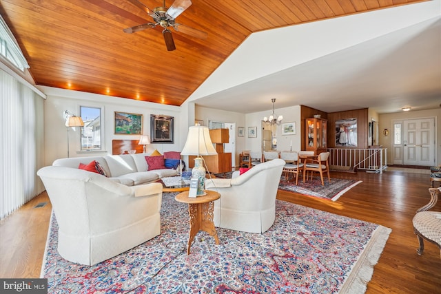 living room with vaulted ceiling, ceiling fan with notable chandelier, dark hardwood / wood-style floors, and wooden ceiling