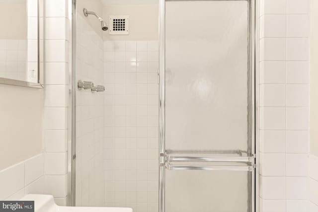 bathroom featuring a shower with shower door