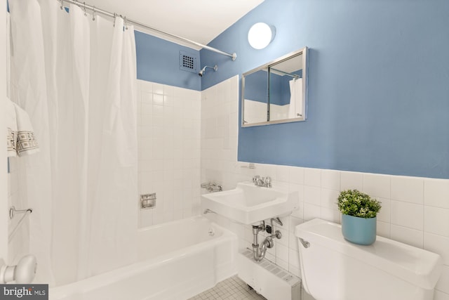 full bathroom with sink, shower / bathtub combination with curtain, tile walls, tile patterned flooring, and toilet