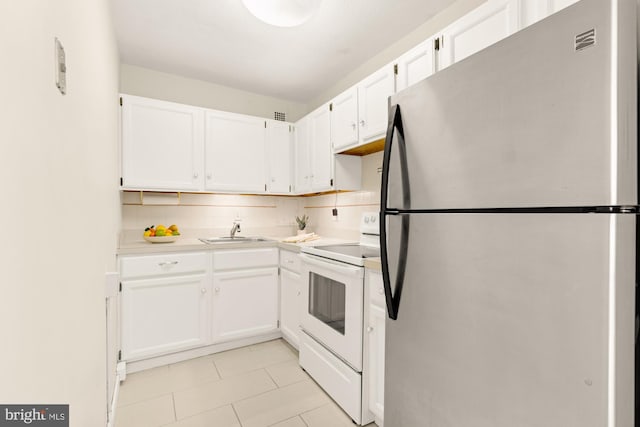 kitchen featuring stainless steel fridge, tasteful backsplash, sink, electric stove, and white cabinets