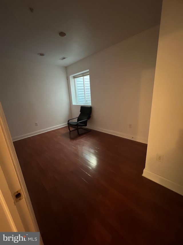 empty room featuring dark wood finished floors and baseboards