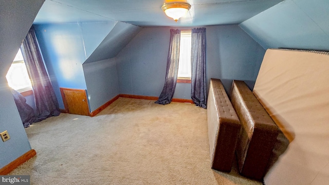 interior space featuring light carpet and vaulted ceiling