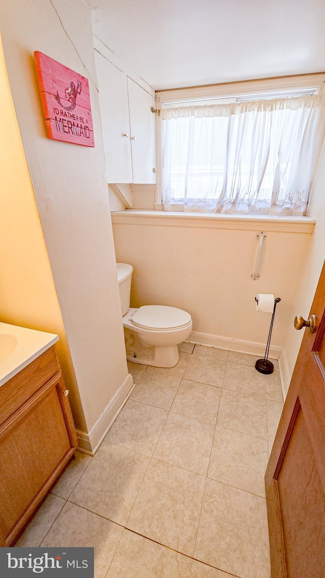 bathroom featuring tile patterned flooring, vanity, and toilet