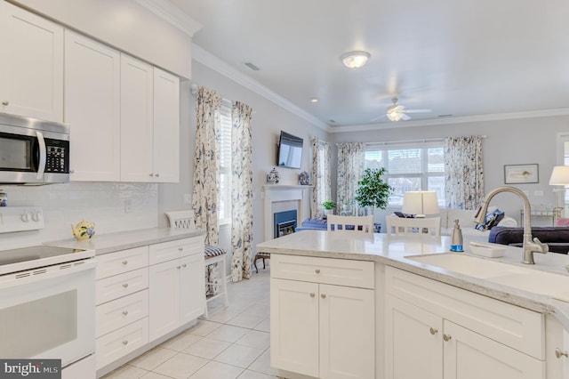 kitchen with sink, light tile patterned flooring, ceiling fan, white electric range, and crown molding