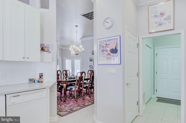 interior space featuring an inviting chandelier, french doors, ornamental molding, and light tile patterned floors