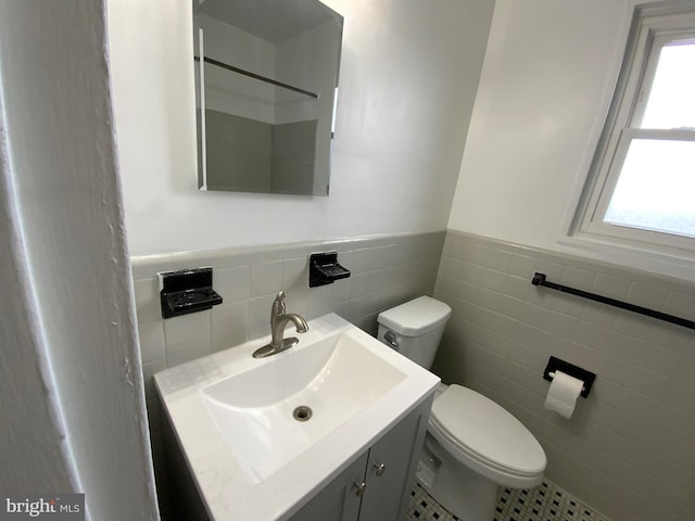 bathroom with tile patterned floors, vanity, tile walls, and toilet