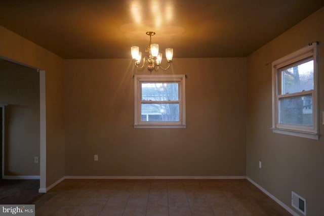 empty room featuring a chandelier