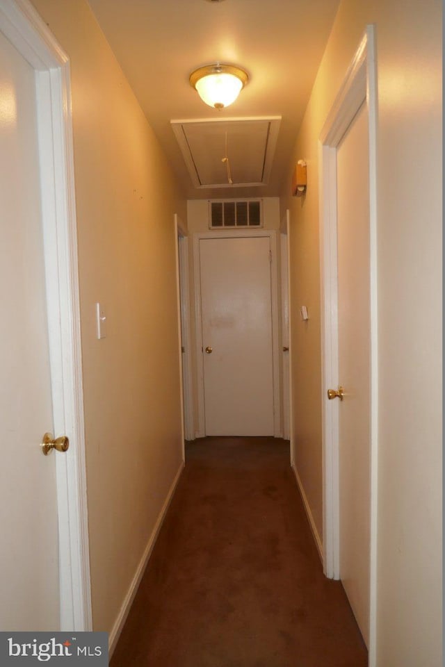 hallway featuring dark carpet