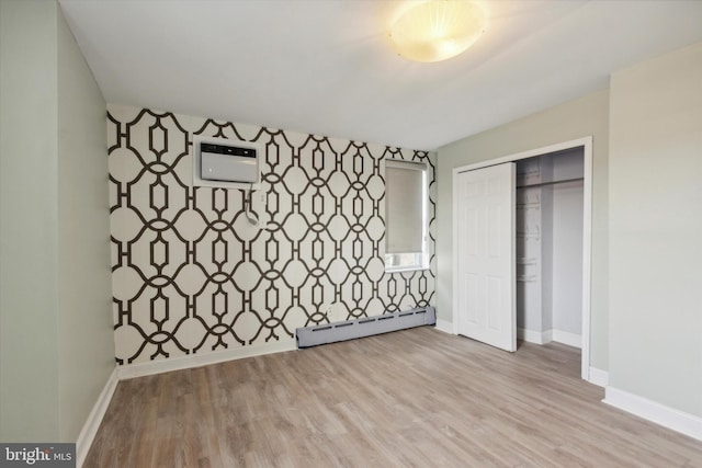 unfurnished bedroom featuring a closet, a baseboard radiator, and light hardwood / wood-style floors