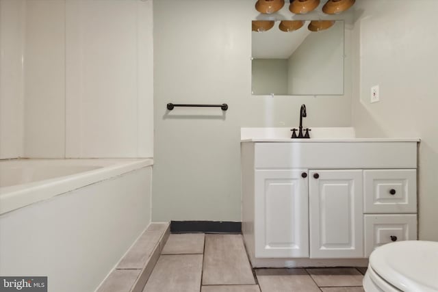 bathroom featuring tile patterned floors, a washtub, vanity, and toilet