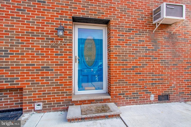 doorway to property featuring a wall unit AC