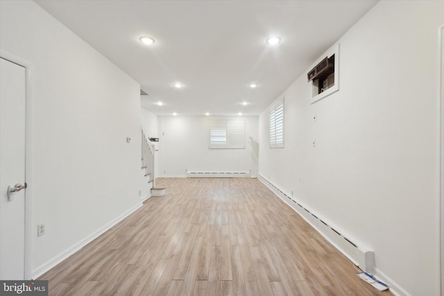 spare room featuring light hardwood / wood-style floors and a baseboard heating unit