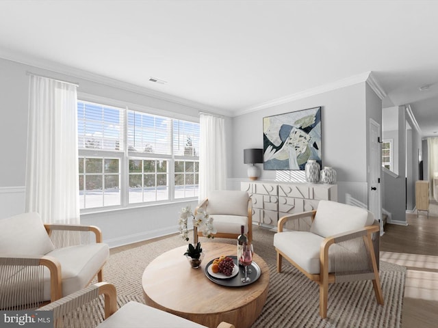 sitting room with hardwood / wood-style floors and crown molding