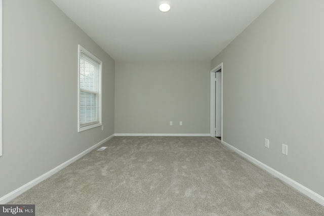 unfurnished room with light carpet