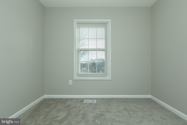 spare room featuring light colored carpet