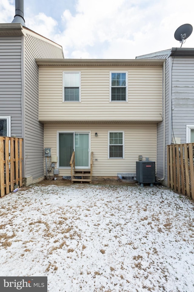 snow covered house featuring cooling unit