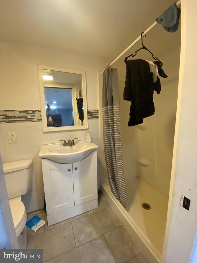 bathroom featuring a shower with curtain, tile patterned floors, toilet, vanity, and tile walls