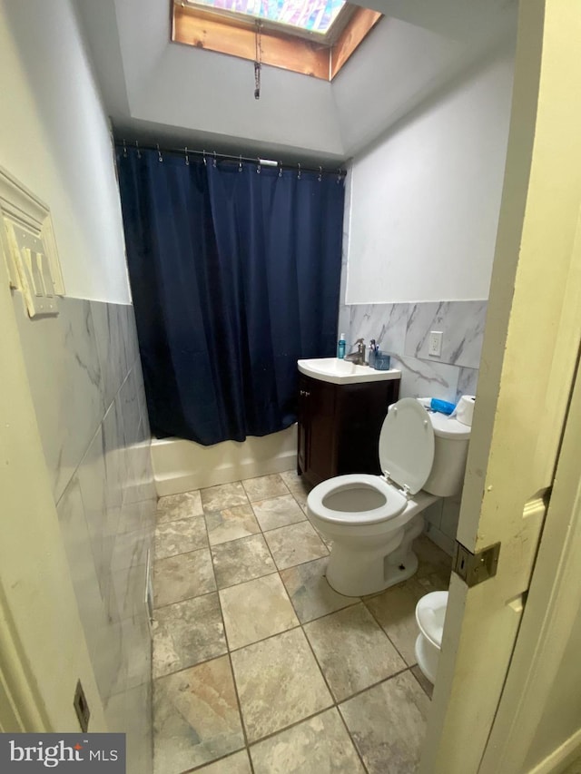 full bathroom with vanity, shower / bath combination with curtain, tile walls, and toilet