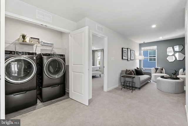 washroom with separate washer and dryer and light carpet