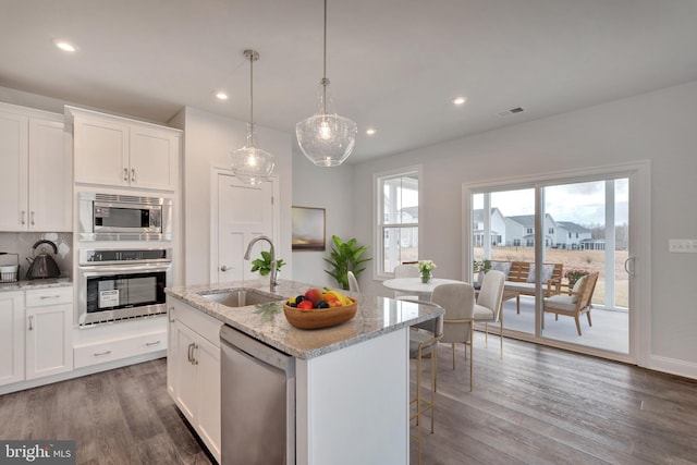 kitchen featuring a kitchen island with sink, white cabinetry, sink, and stainless steel appliances