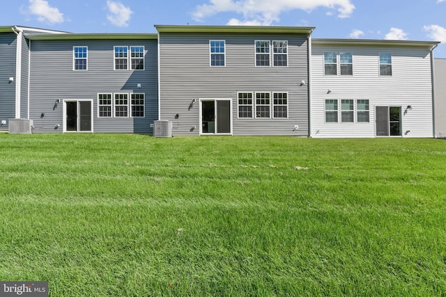 back of property featuring a lawn and central air condition unit