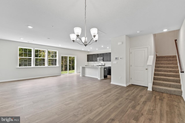 unfurnished living room featuring a notable chandelier, dark hardwood / wood-style flooring, and sink