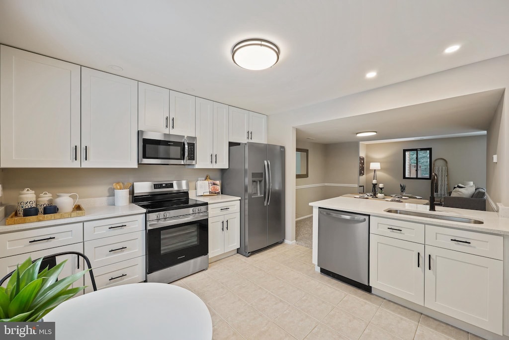 kitchen with sink, white cabinets, and appliances with stainless steel finishes