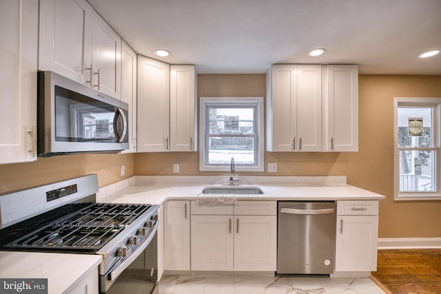 kitchen with sink, stainless steel appliances, and white cabinetry