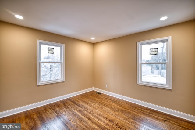 unfurnished room featuring hardwood / wood-style floors and a healthy amount of sunlight