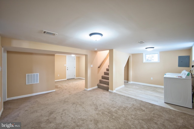 basement with electric panel, light carpet, and washing machine and clothes dryer