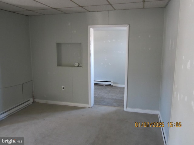 spare room with carpet flooring and a baseboard heating unit