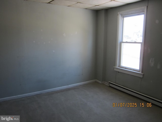 carpeted empty room with a baseboard radiator