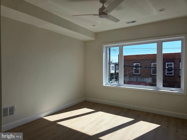 unfurnished room with visible vents, baseboards, and wood finished floors