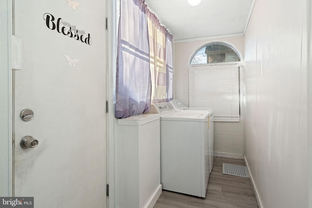 laundry area featuring separate washer and dryer and light hardwood / wood-style floors