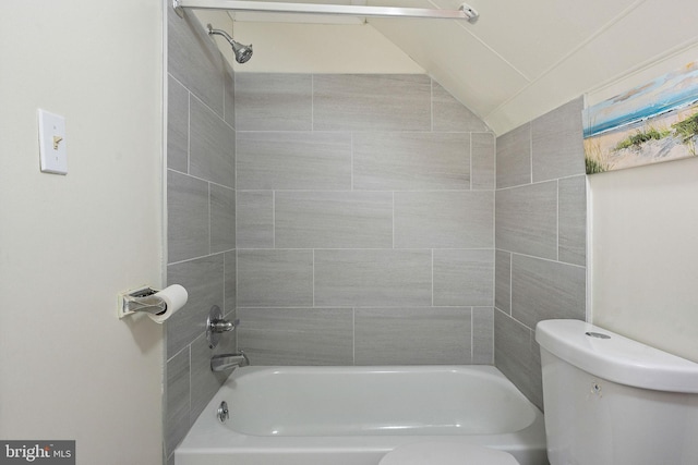 bathroom featuring tiled shower / bath combo, vaulted ceiling, and toilet