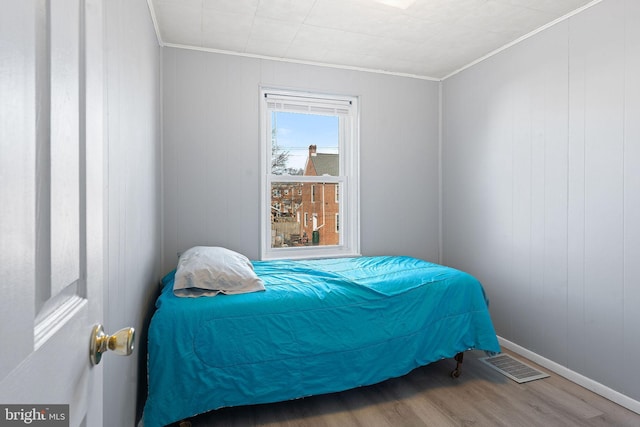 bedroom featuring hardwood / wood-style flooring and ornamental molding