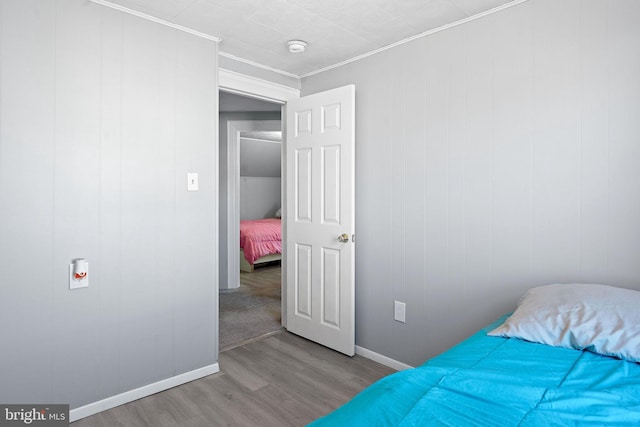 bedroom with crown molding and light hardwood / wood-style floors