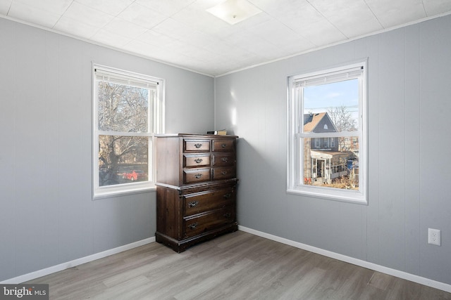 bedroom with multiple windows and light wood-type flooring