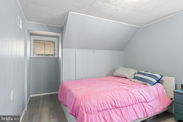 bedroom with lofted ceiling and wood-type flooring