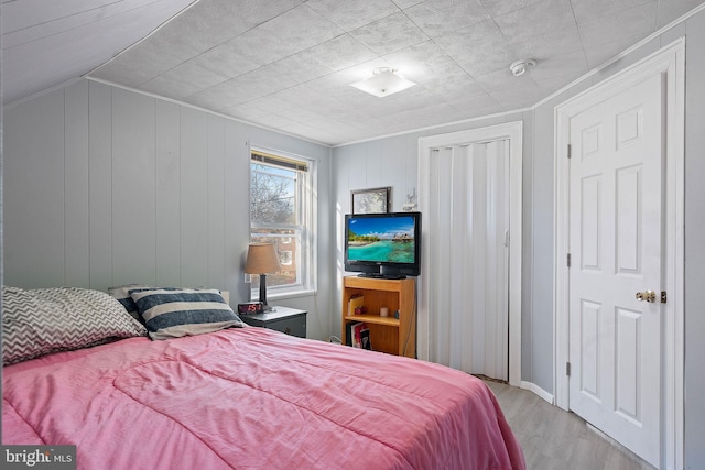 bedroom with light hardwood / wood-style floors and a closet