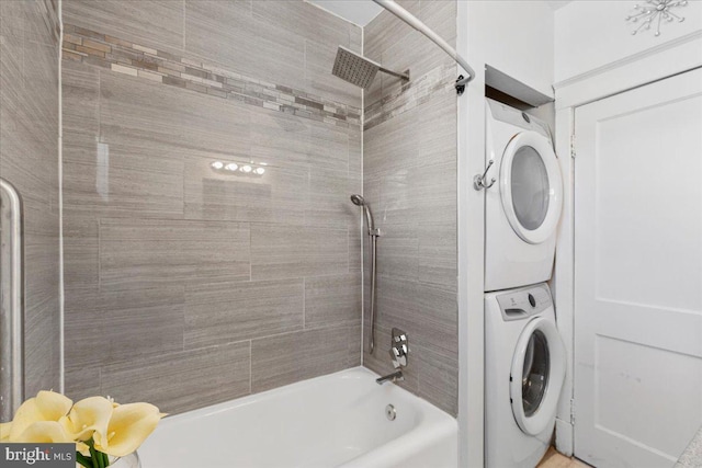 bathroom featuring stacked washing maching and dryer and tiled shower / bath