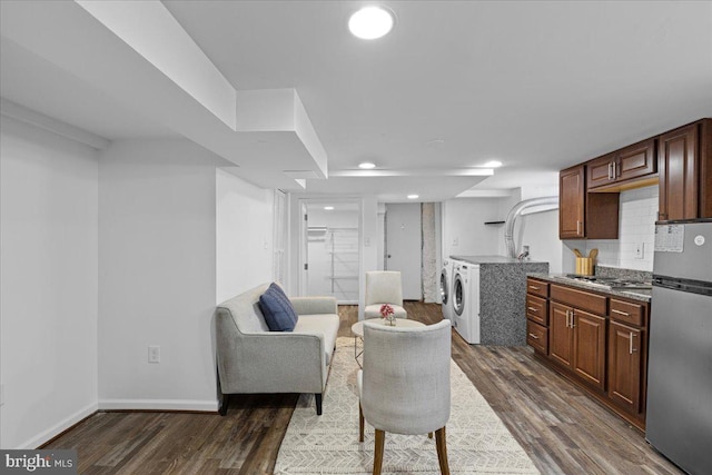 living room with dark wood-type flooring and washing machine and clothes dryer