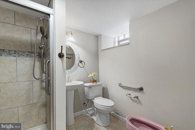 bathroom featuring tile patterned floors, sink, toilet, and tiled shower