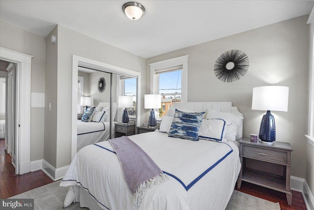 bedroom with dark wood-type flooring and a closet