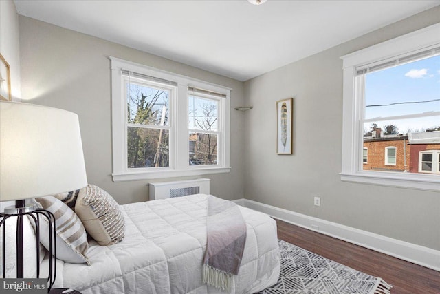 bedroom with radiator heating unit and hardwood / wood-style flooring