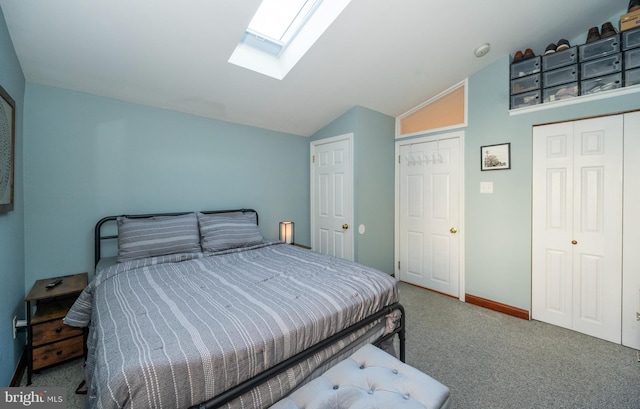 bedroom with vaulted ceiling with skylight and carpet floors