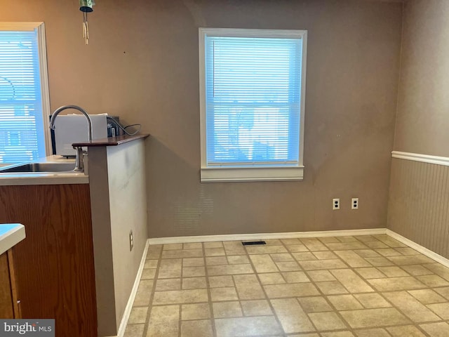 kitchen featuring a sink, visible vents, and baseboards